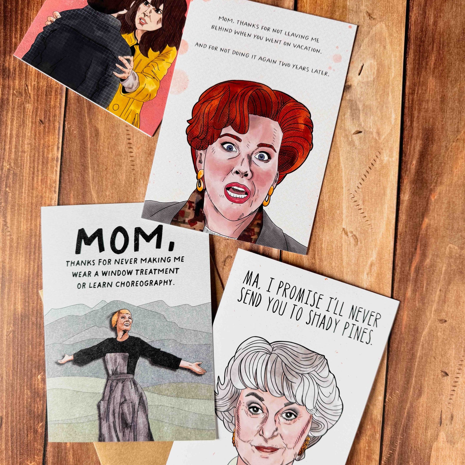 Four funny Mother's Day cards with caricatures and humorous text on a wooden surface